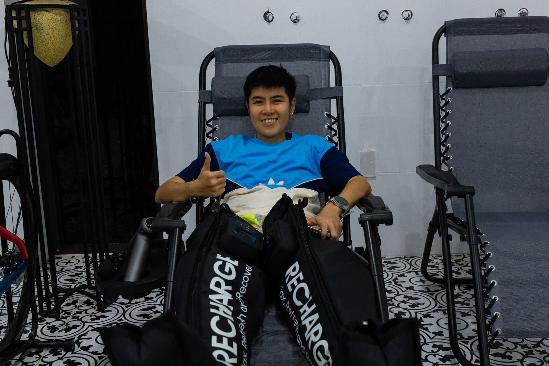 Camp athlete in a reclining chair wearing pneumatic compression boots